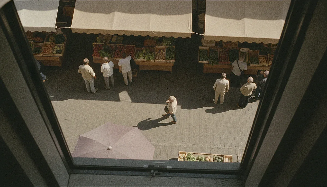 A weekend market street seen from above: adults in small groups of two and three, and one person walking alone through the middle.